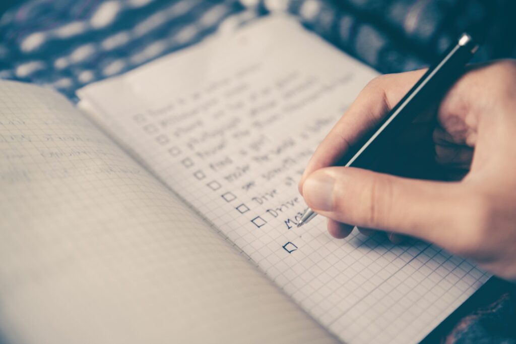 goal setting activities for adults - Image of a person writing notes in a notebook